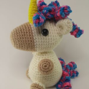 A crochet unicorn with a white background