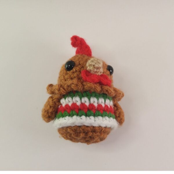 A crochet Christmas chicken with a white background