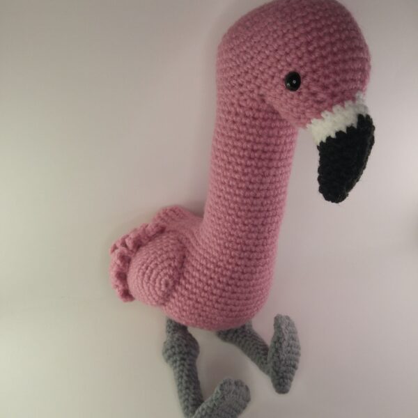 A crochet flamingo with a white background