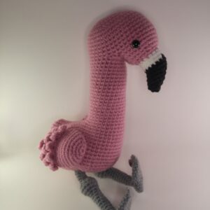 A crochet flamingo with a white background