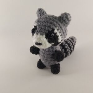 A crochet raccoon with a white background